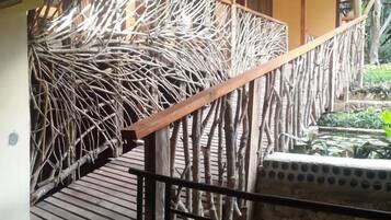 Un escalier en bois doté d’une rampe au design original, réalisée à l’aide d’un motif tressé, menant à un niveau supérieur.