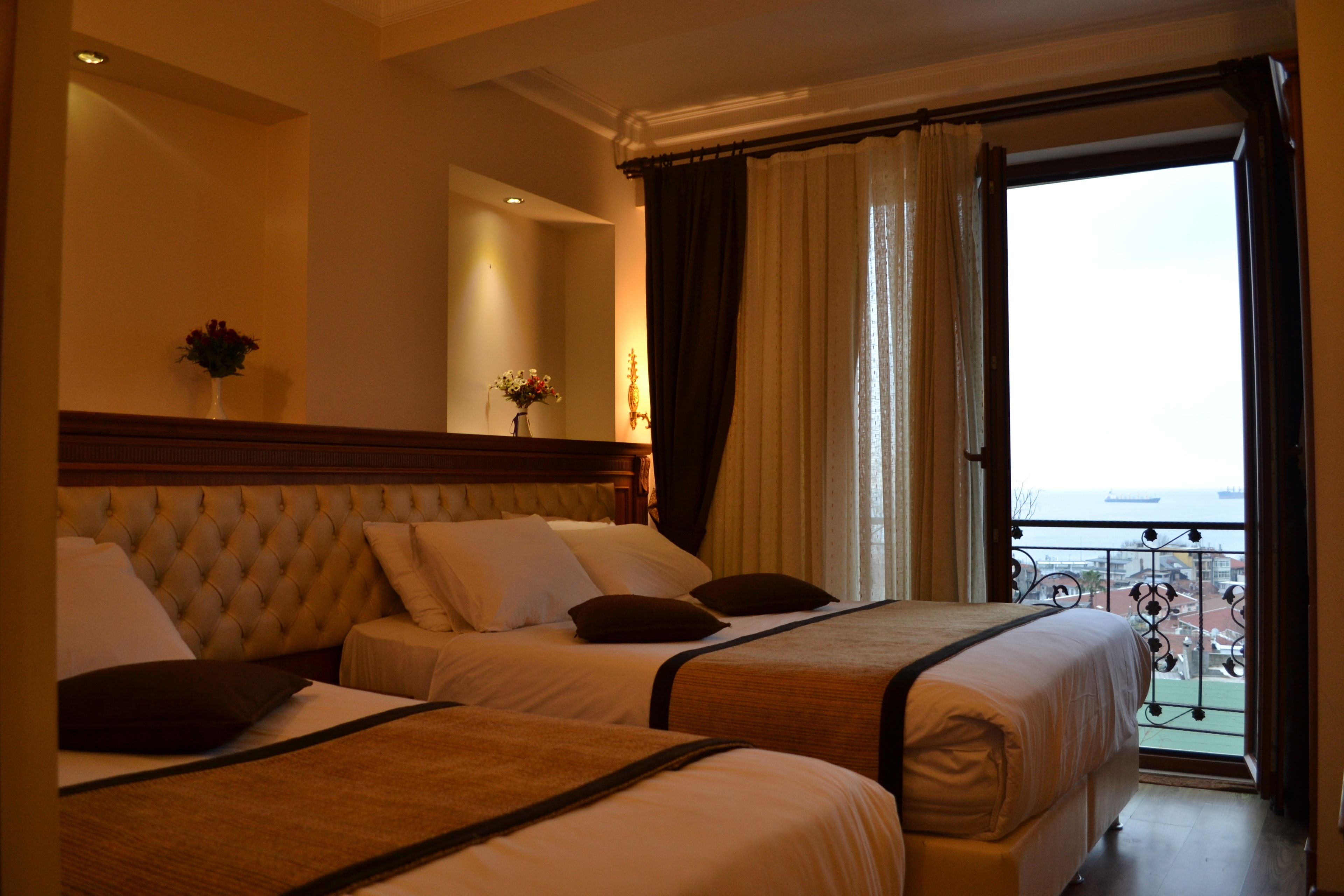 Deluxe driepersoonskamer, uitzicht op zee | Een minibar, een kluis op de kamer, een bureau, verduisterende gordijnen