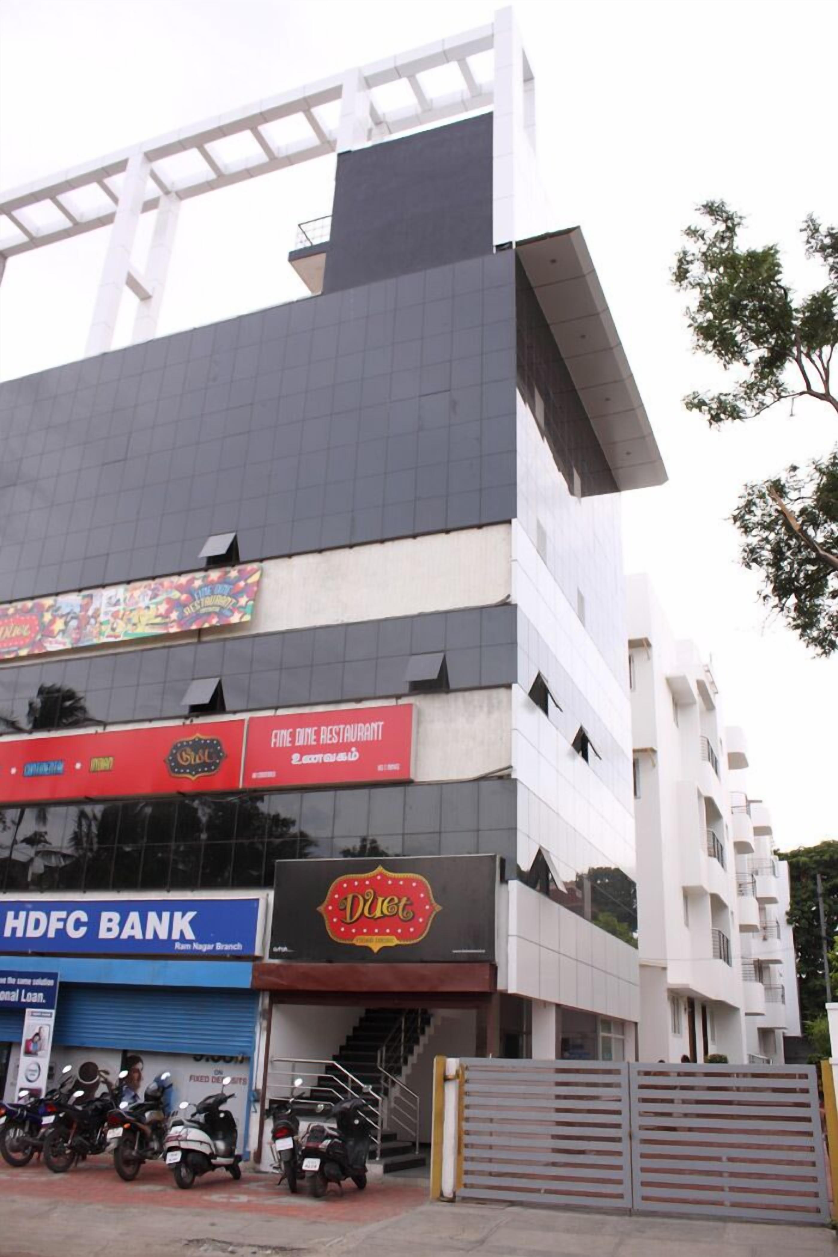 A multi-story building with a restaurant on the ground floor, a bank on the second floor, and a Duco restaurant on the third floor.