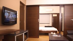 Ein Hotelzimmer mit einem Bett, einem Schreibtisch, einem Fernseher und einem Couchtisch.
