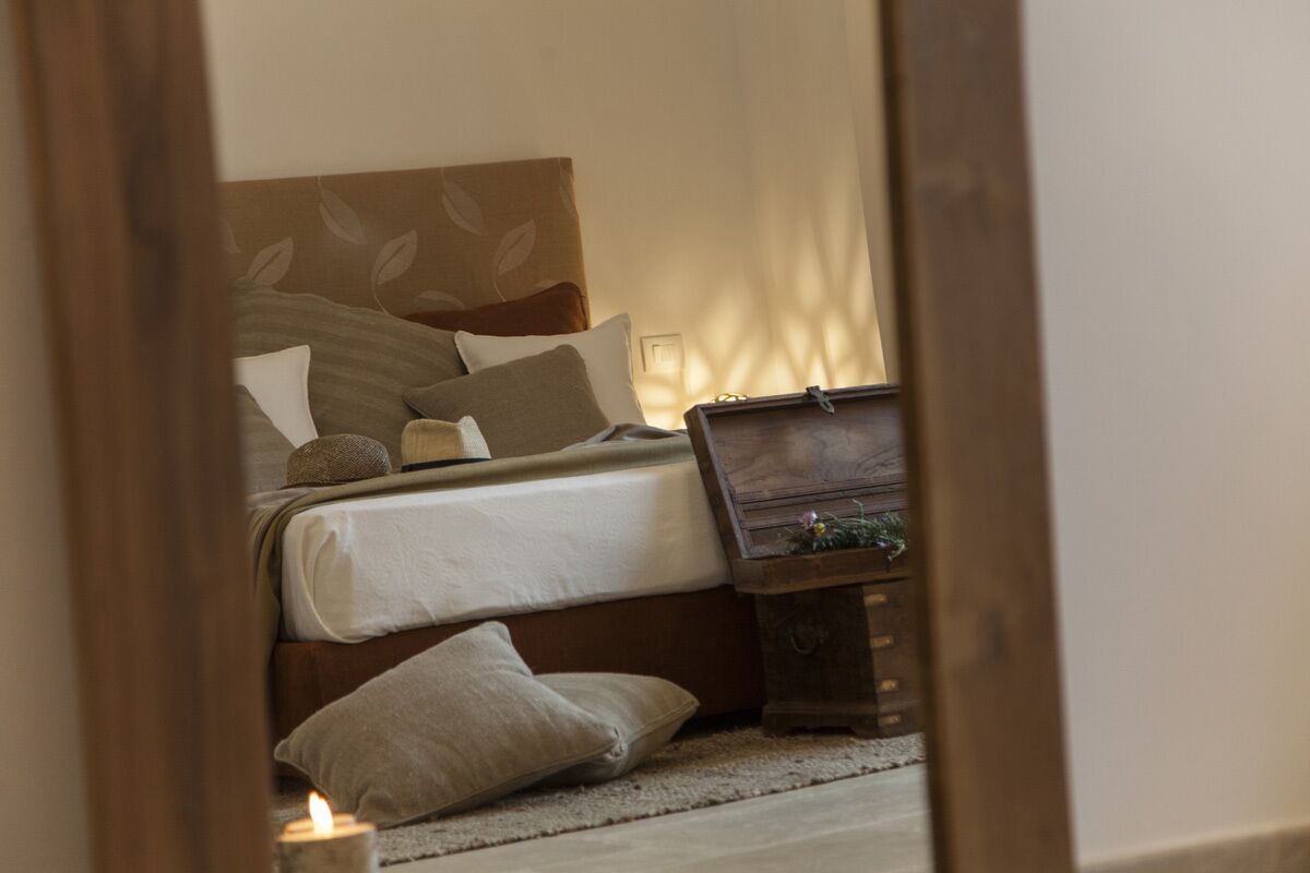 A bedroom with a bed, pillows, a bedside table, and a nightstand.