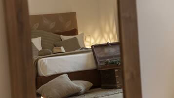 A bedroom with a bed, pillows, a bedside table, and a nightstand.