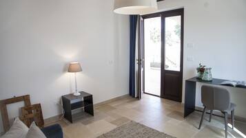 Una sala de estar moderna con un sofá, una lámpara, una mesita y un escritorio con una silla.