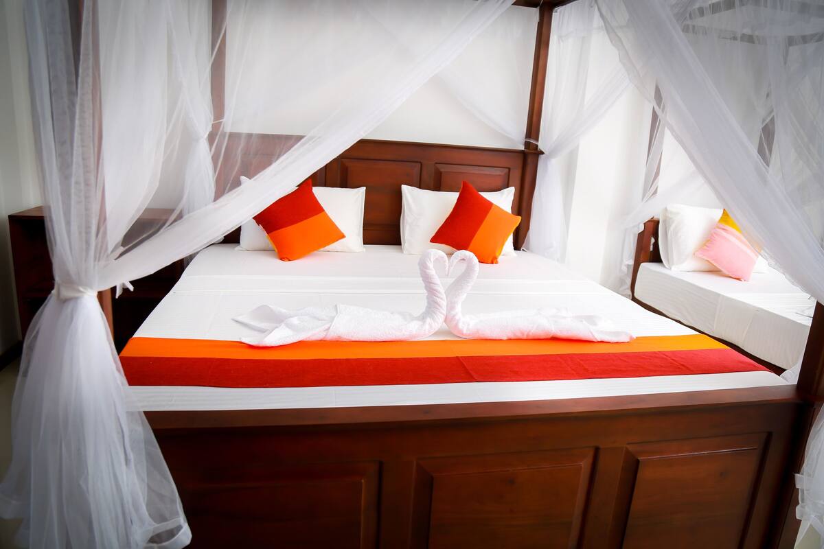 Deluxe Triple Room, Beach View | Desk, soundproofing, iron/ironing board, bed sheets