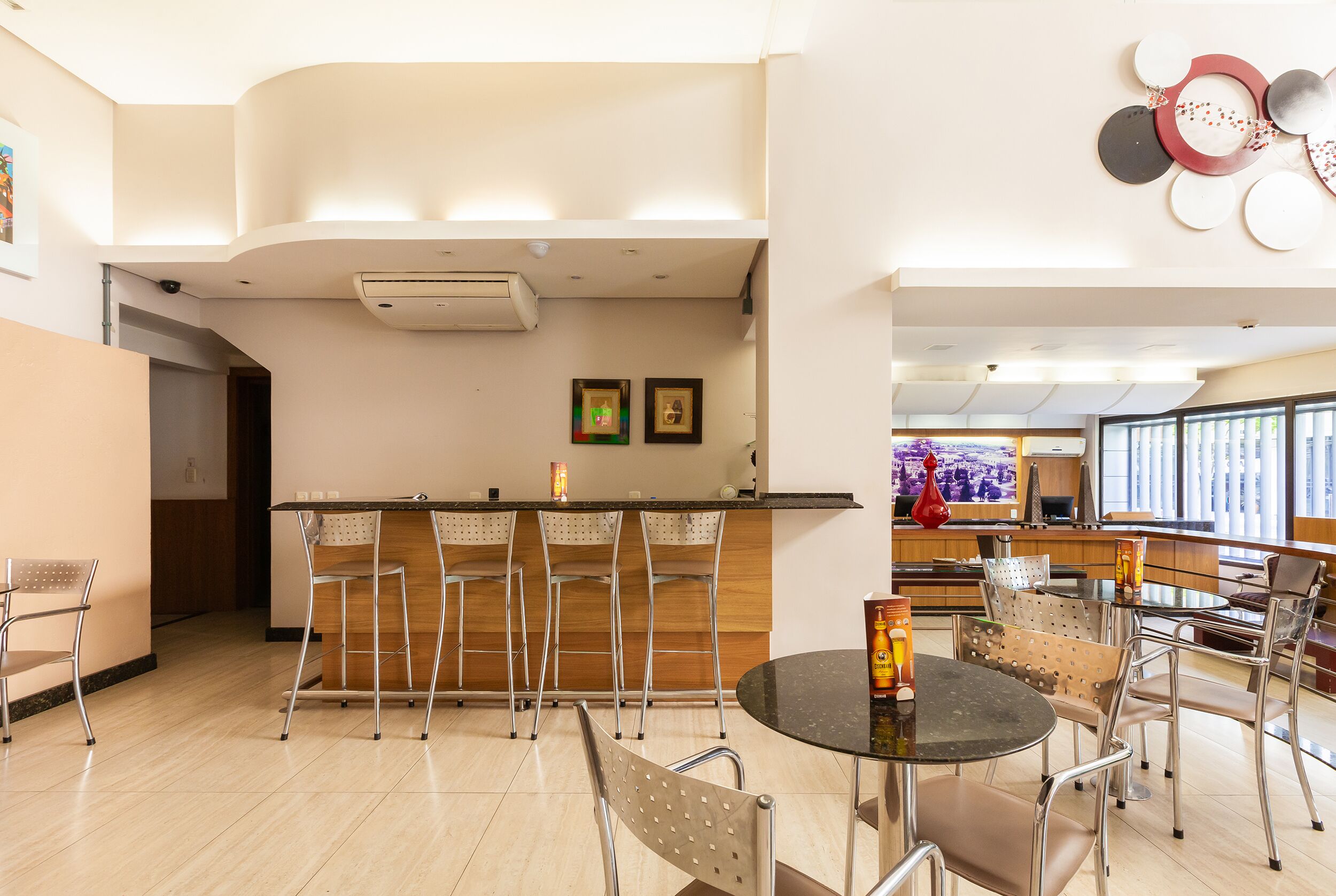 Uma cozinha moderna com área de bar, banquetas e uma mesa de jantar com cadeiras.