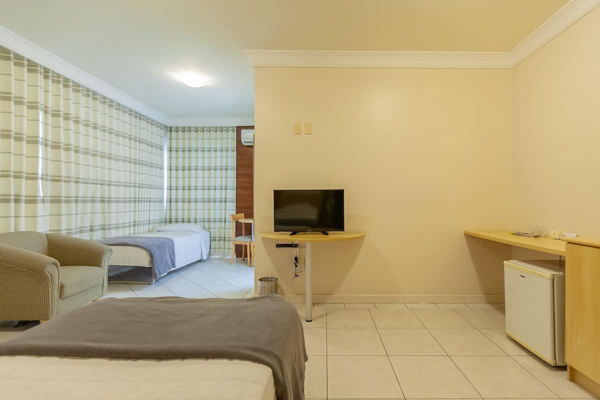 Deluxe Triple Room | Minibar, in-room safe, desk, blackout drapes