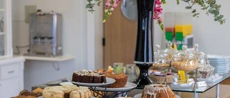 A buffet table with various baked goods and desserts.