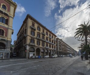 Un edificio storico con più piani, ampie finestre e un ingresso imponente con un arco.