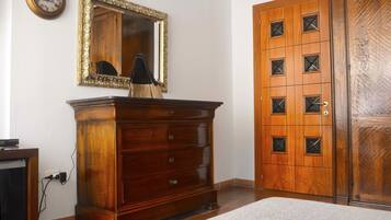 Ein Zimmer mit einem Holzkapuzen, einem Spiegel, einer Uhr und einem Schrank.