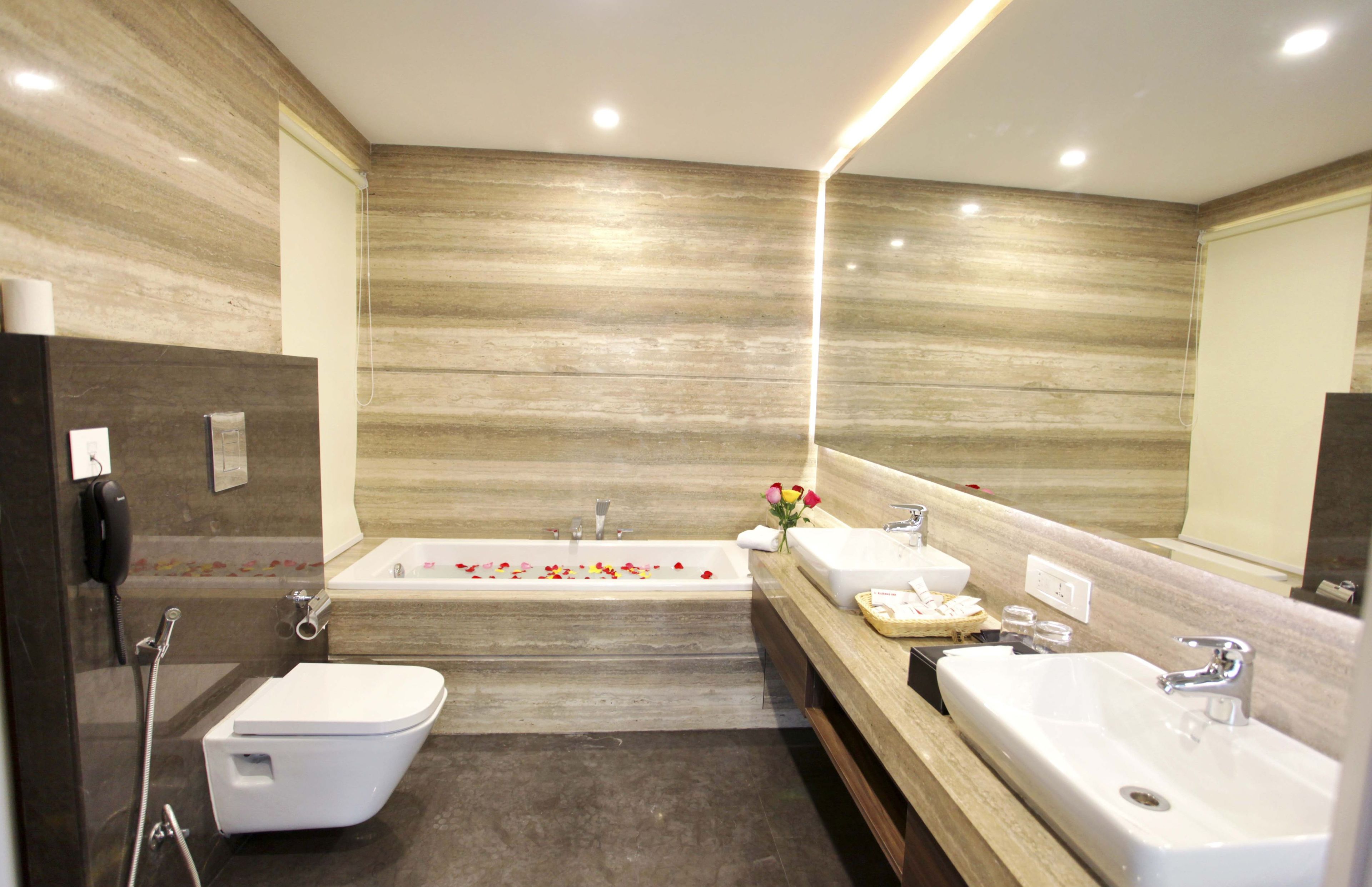 Un baño moderno con bañera, dos lavamanos y un inodoro.