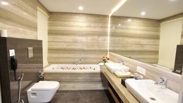 Un baño moderno con bañera, dos lavamanos y un inodoro.