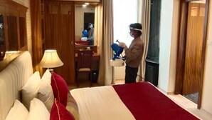 Una habitación de hotel con una cama grande, un escritorio y un ventilador de techo.