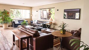 A modern living room with a sofa set, a coffee table, and a TV mounted on the wall. - Hotel Pousada Ourinhos (Ourinhos)
