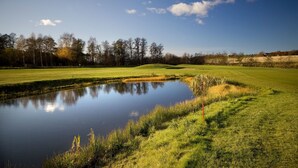 A golf course with a pond, trees, and a clear sky. - Kiladalens golf & Lodge (Nykoping)