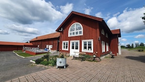 A red wooden building with a large arched window and white trim. - Kiladalens golf & Lodge (Nykoping)