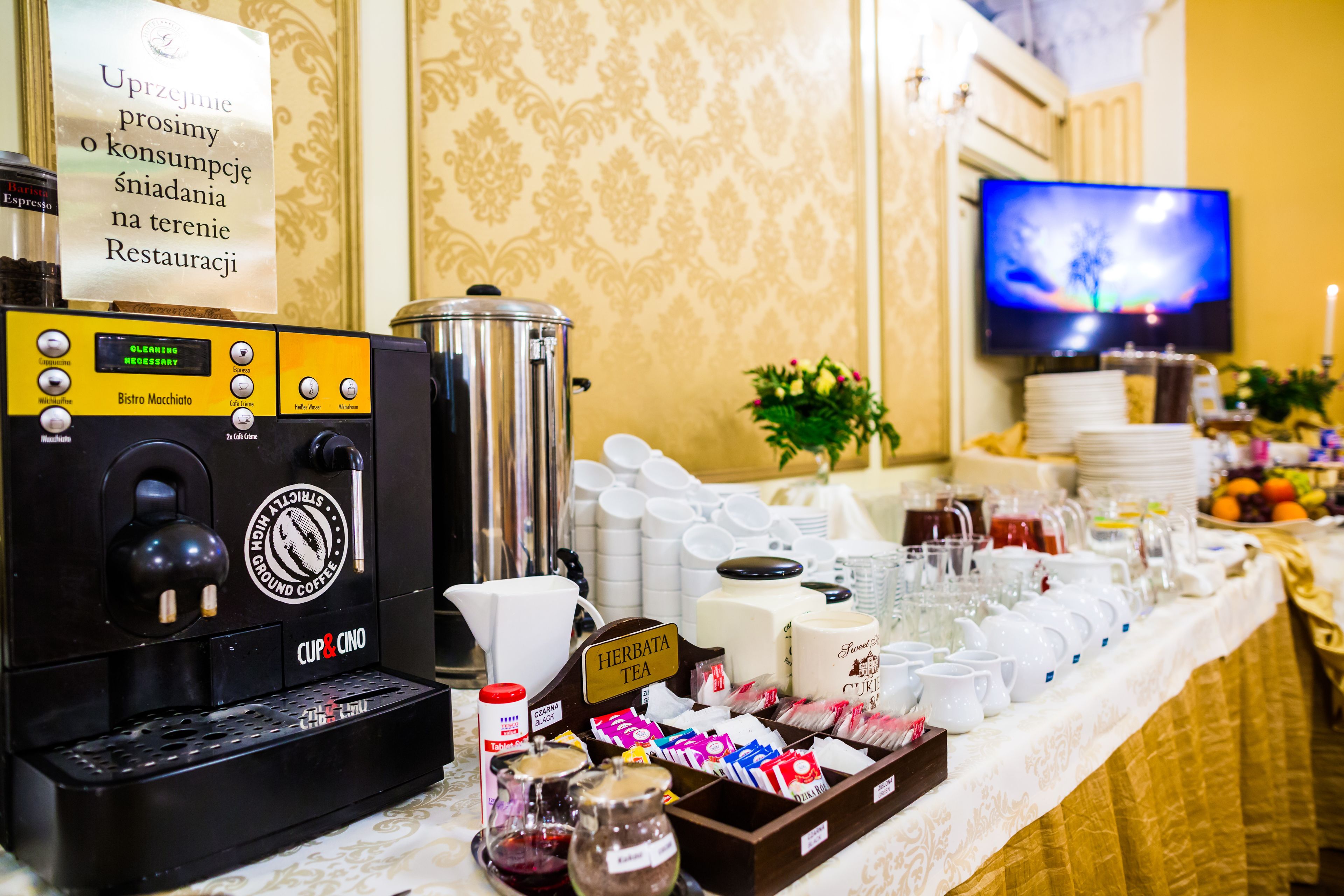 A coffee station with a coffee machine, tea station, and various food items.