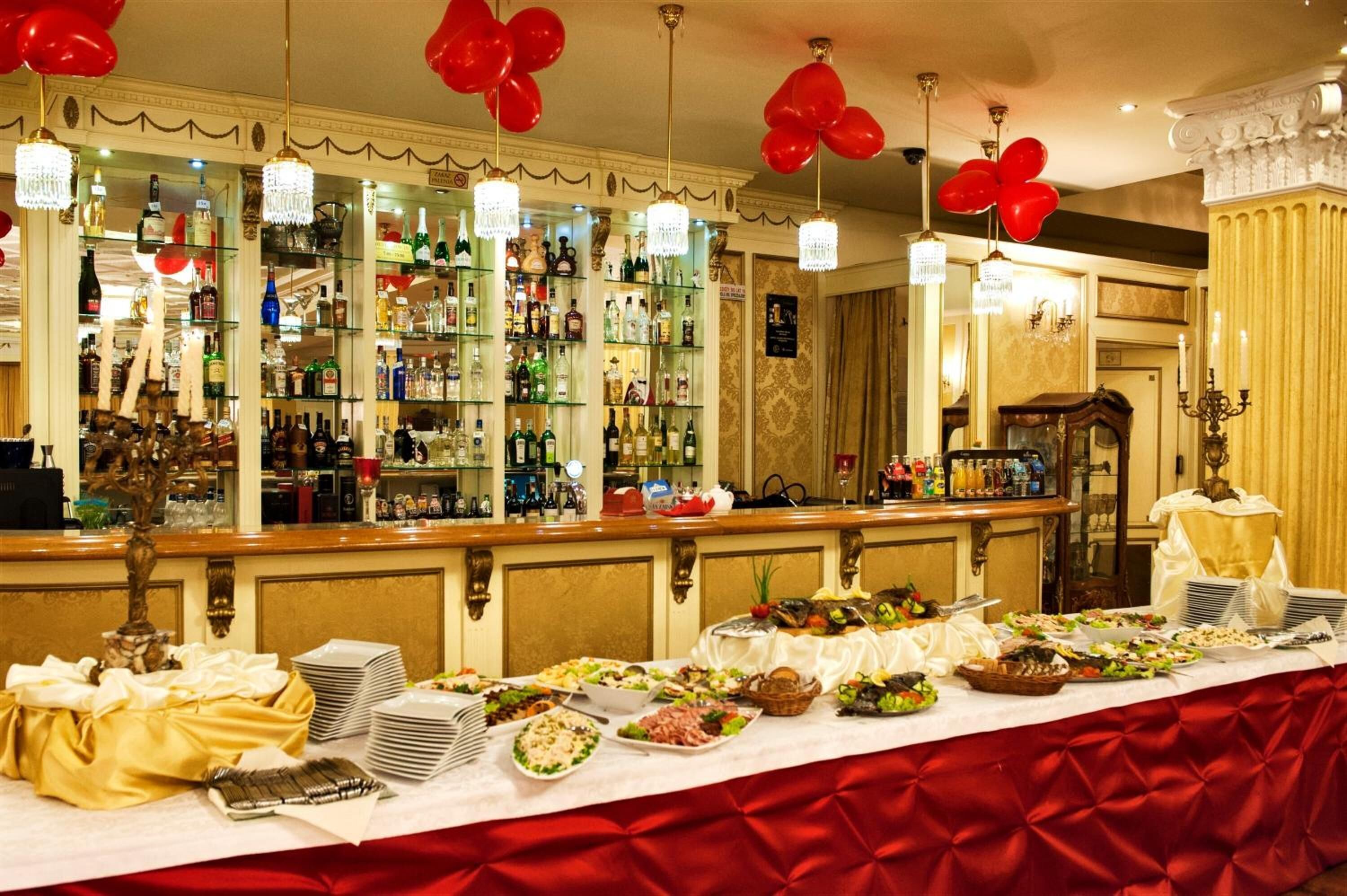 A buffet setup with various food items and a bar area with liquor bottles.