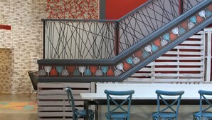 Un interior moderno con una escalera, una zona de estar y una pared de ladrillo.