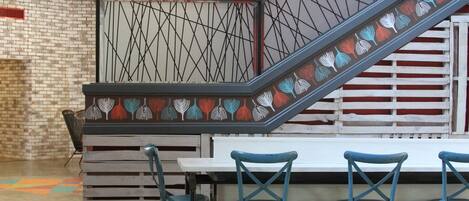 A modern interior with a staircase, seating area, and a brick wall.