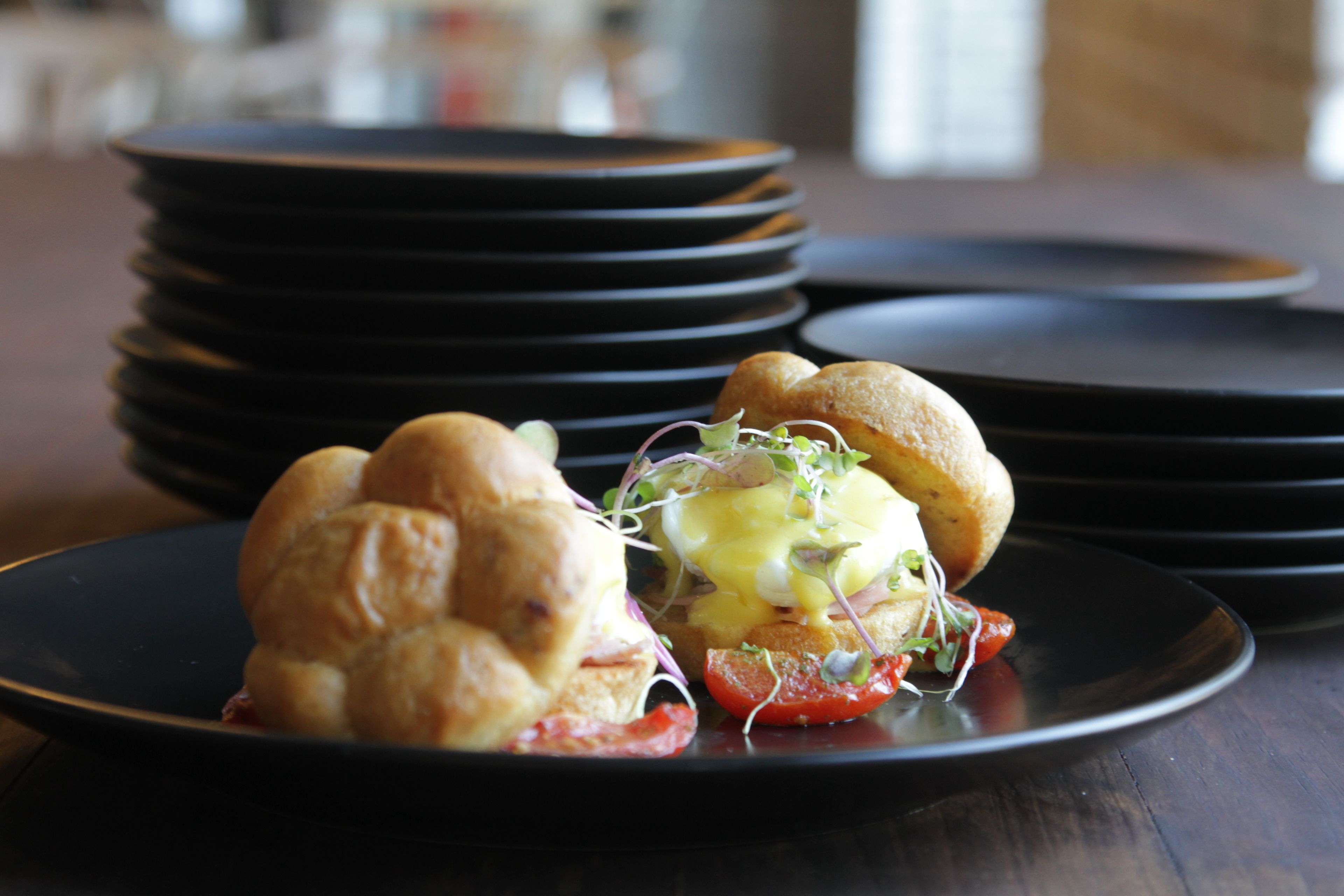 A stack of black plates on a wooden table.