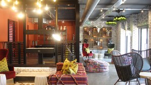 Amplia sala de estar con mesa de billar, asientos cómodos y diversos objetos decorativos.