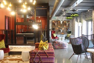 Amplia sala de estar con mesa de billar, asientos cómodos y diversos objetos decorativos.