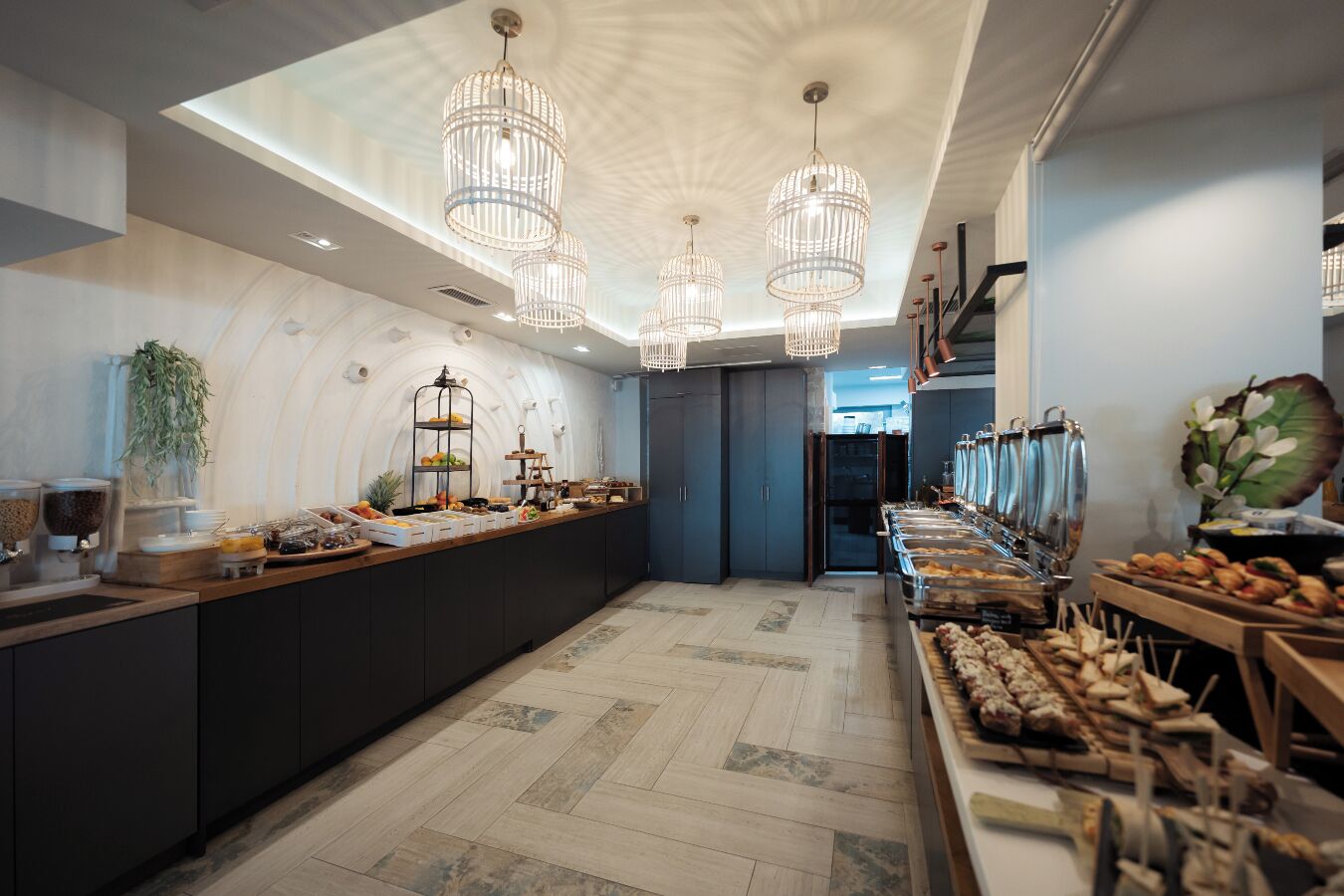 A modern breakfast bar with a variety of food options, pendant lighting, and a view into the kitchen area.