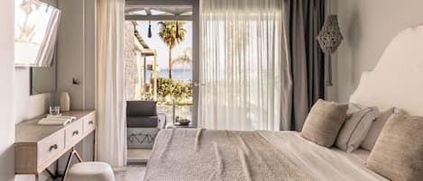 Un dormitorio con una cama grande, un escritorio y vistas al exterior.