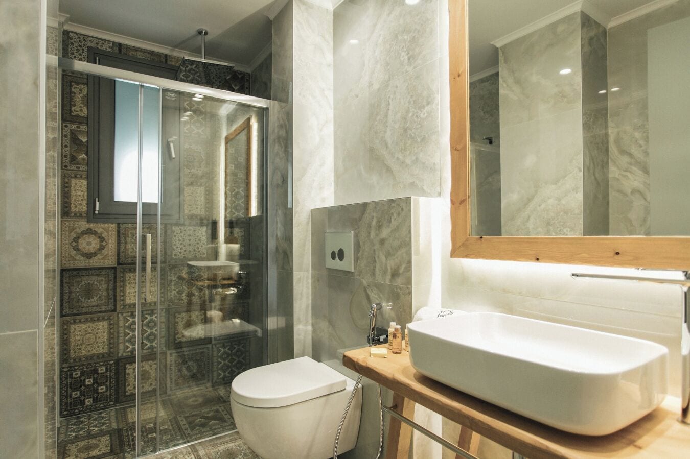A modern bathroom with a glass-enclosed shower, a white toilet, and a large freestanding sink.