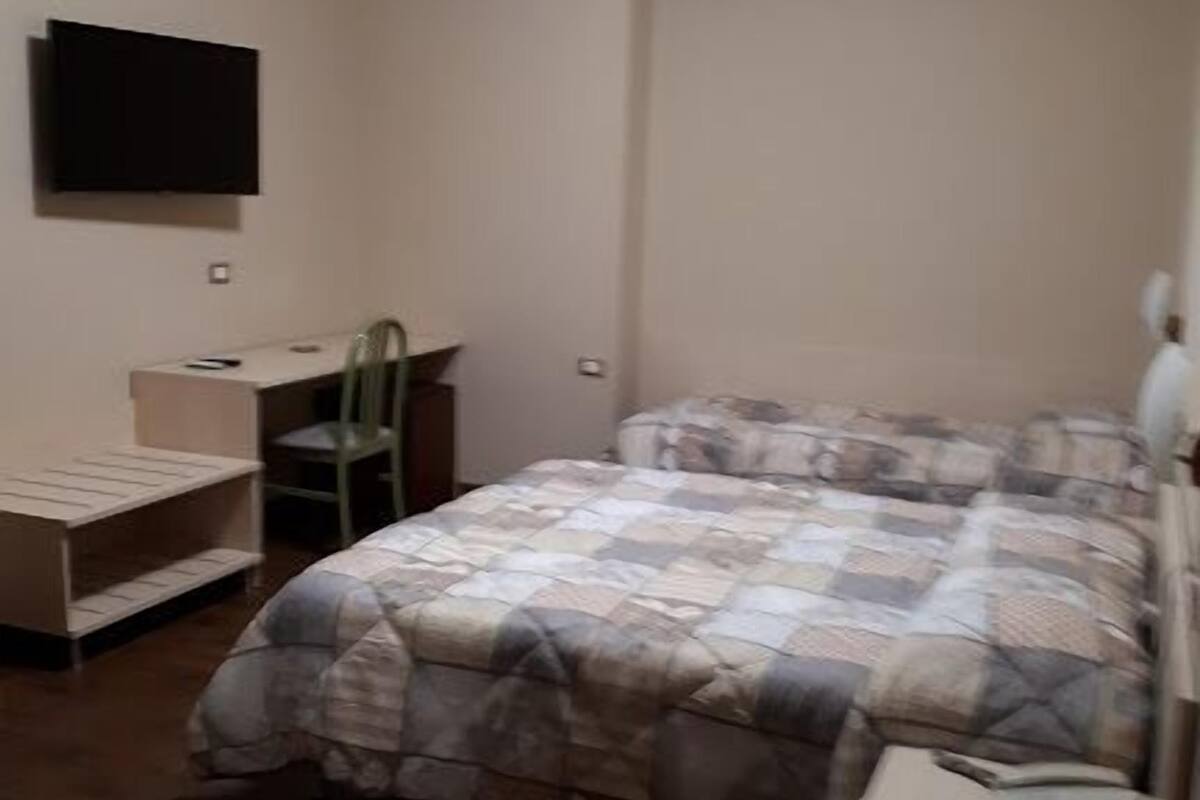 Un dormitorio con cama, escritorio y silla.
