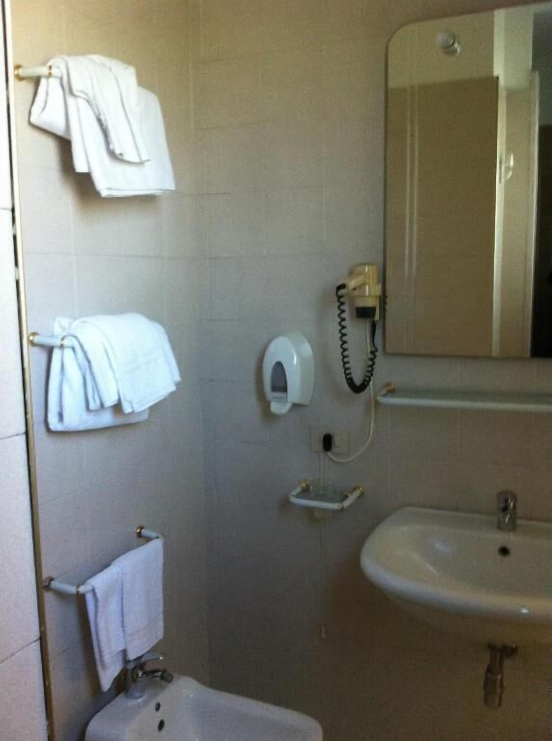 Une salle de bain équipée d’un lavabo, d’un miroir, d’un porte-serviettes et d’un téléphone.