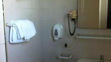 Une salle de bain équipée d’un lavabo, d’un miroir, d’un porte-serviettes et d’un téléphone.