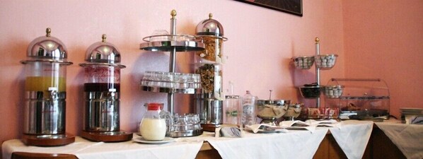 Montaje tipo bufé con varias estaciones de servicio, que ofrece una variedad de alimentos y bebidas.