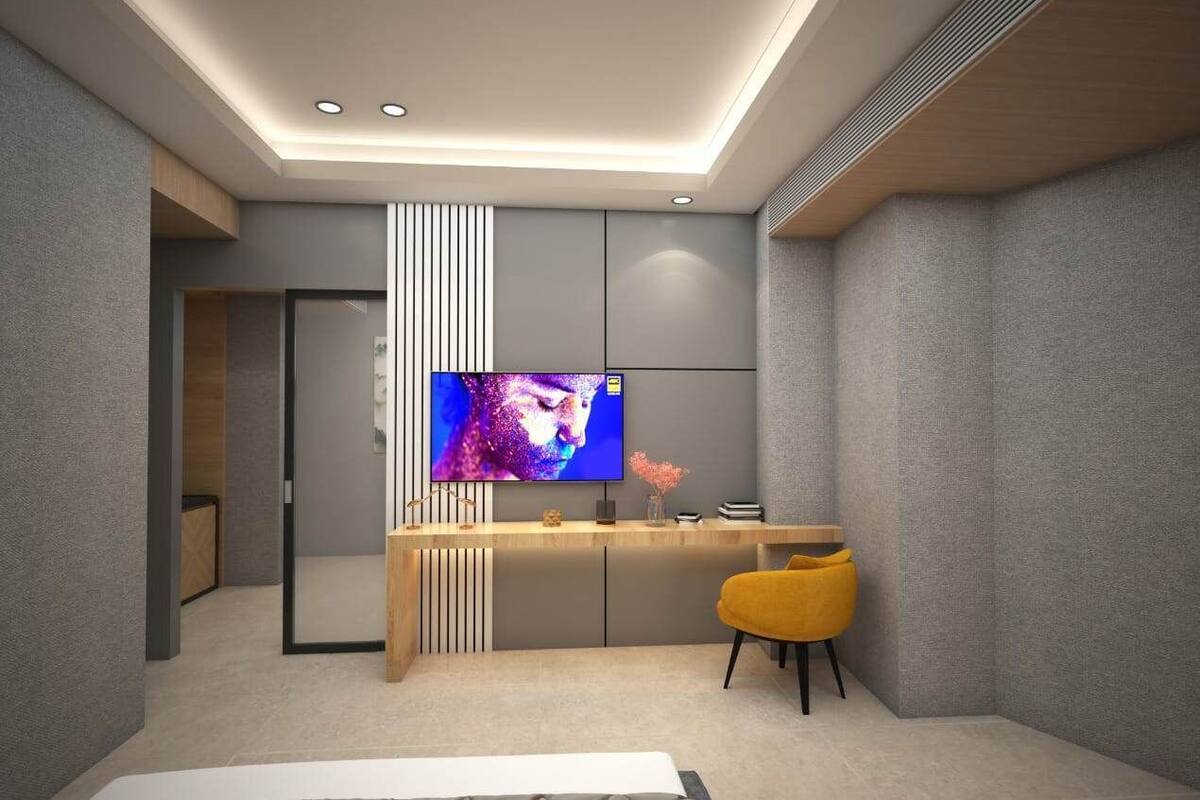 A modern living room with a flat-screen TV, a yellow chair, and a wooden desk.