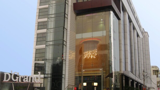 A modern hotel building with a large glass facade, a prominent entrance with a staircase, and a sign reading "D'Grand." - Hotel D Grand (Bareilly)