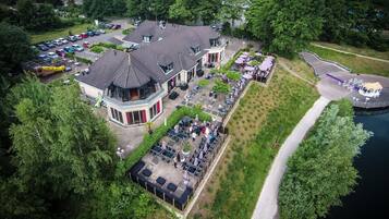 Luchtbeeld van een hotel met een parkeerplaats, een terras en een meer.
