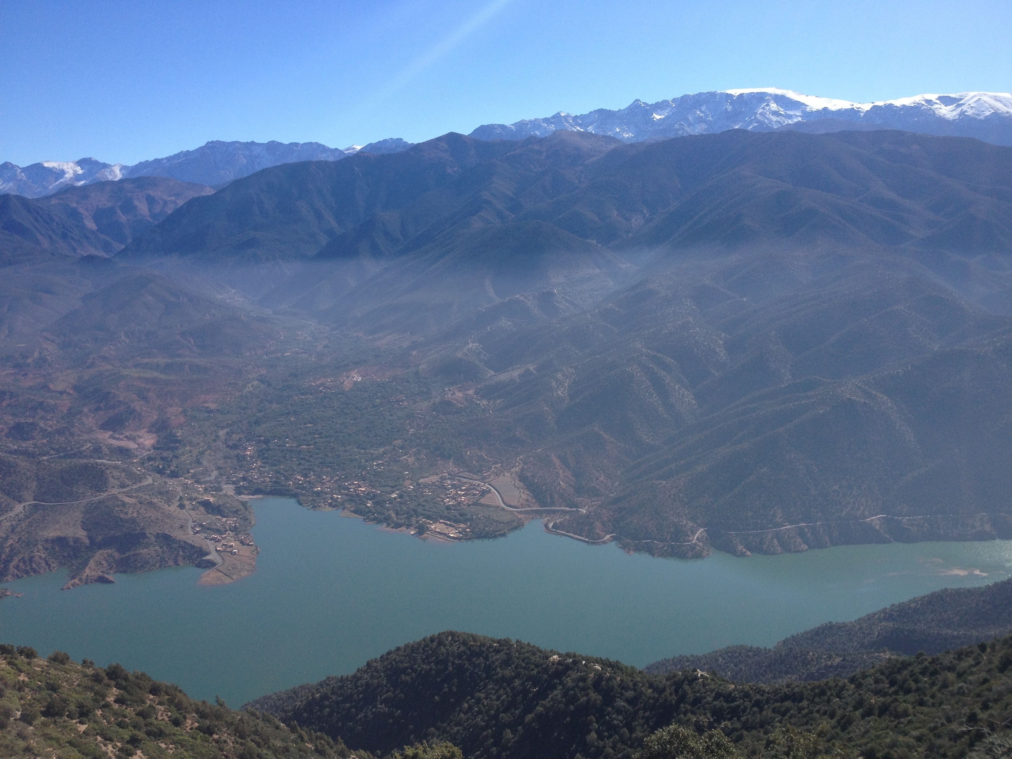 A mountainous landscape with a lake and a small settlement.