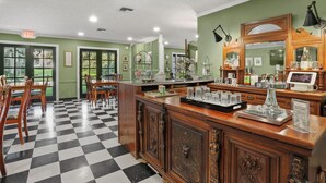 A hotel lobby with a checkered floor, wooden furniture, a reception desk, and a large mirror.