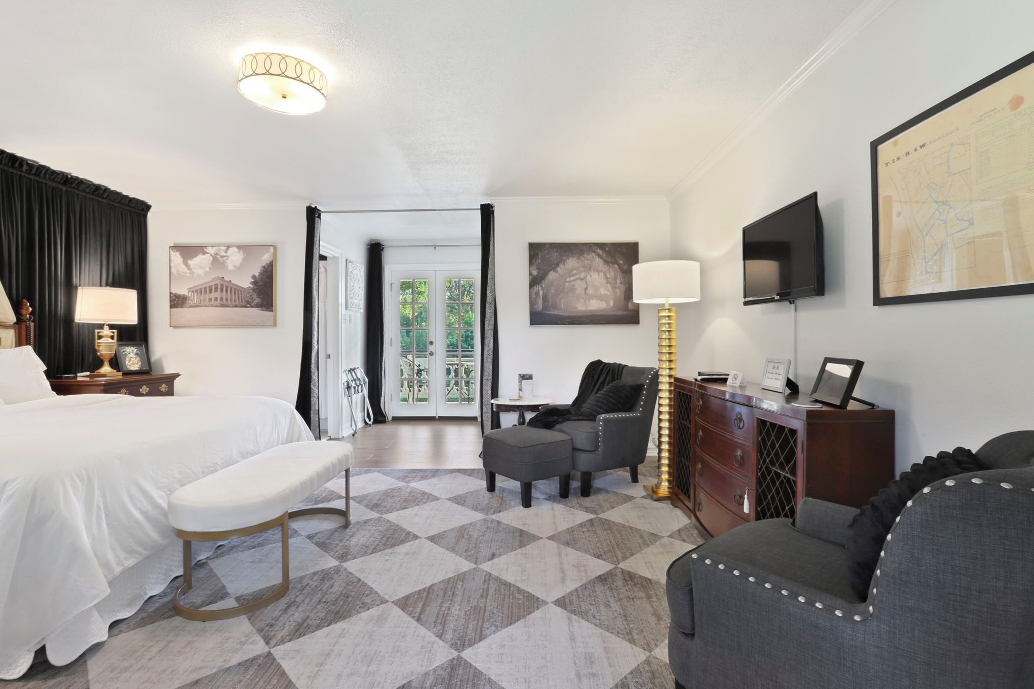 Une chambre d’hôtel équipée d’un lit, d’un bureau, d’une chaise, d’un canapé, d’une lampe et d’un téléviseur.