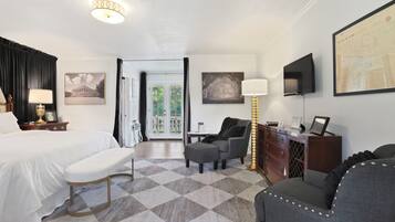 Une chambre d’hôtel équipée d’un lit, d’un bureau, d’une chaise, d’un canapé, d’une lampe et d’un téléviseur.