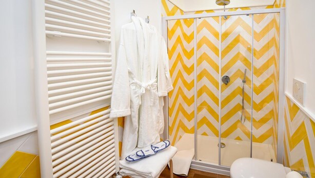 A bathroom with a shower, toilet, and towel rack. - Casa Pantone (Sorrento)
