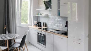 Ett modernt kök med vita skåp, en inbyggd ugn och ett fönster som släpper in naturligt ljus.