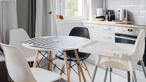 Ett modernt kök med en matplats, med ett runt bord, stolar och en kaffemaskin.