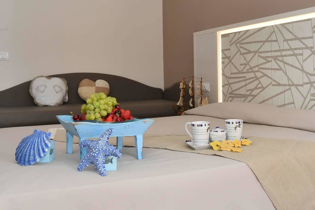 A neatly arranged bedroom with a bed, bedside table, and a wall with geometric patterns.