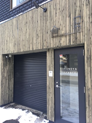 Kuranyya Sapporo's charming facade features a sloped roof and a window above the entrance.