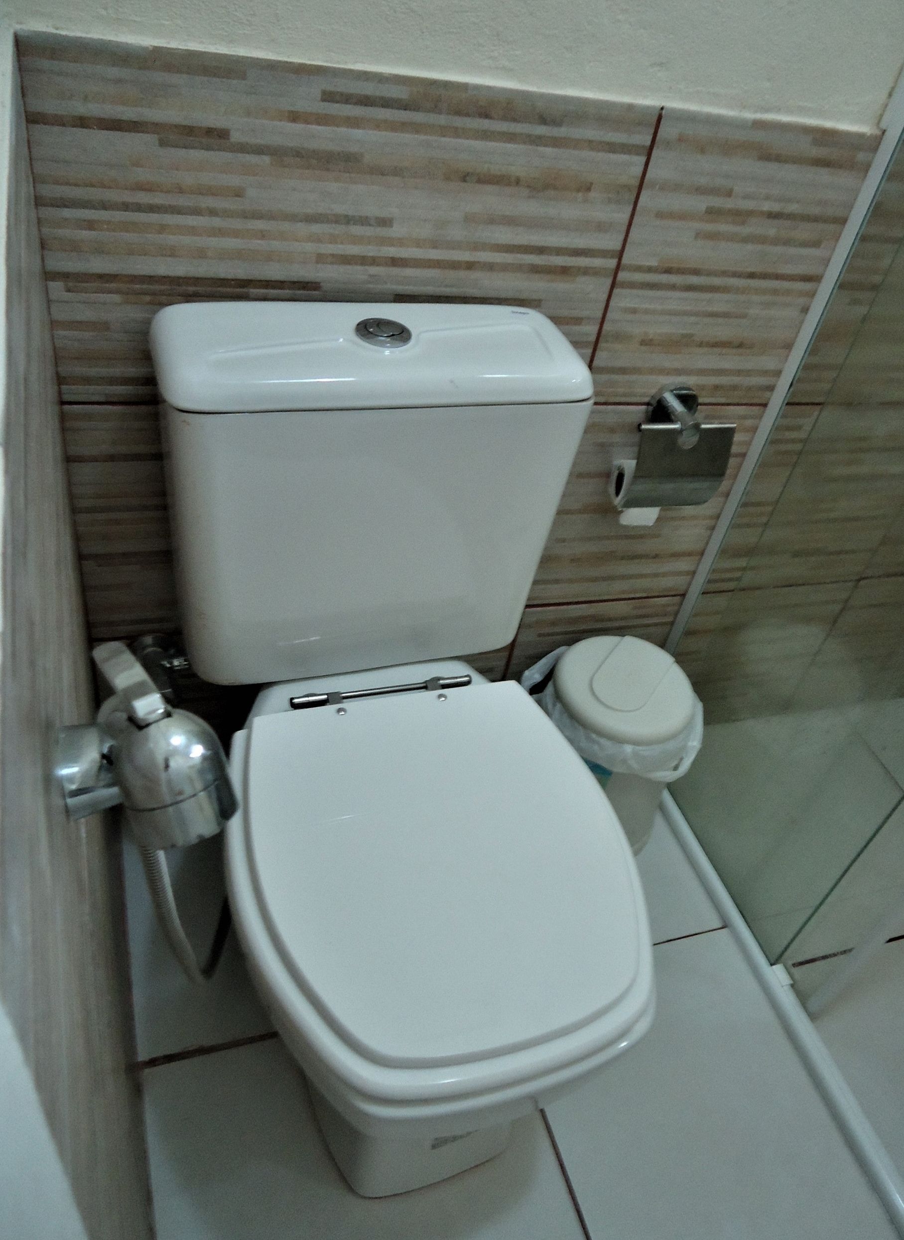 Une salle de bain moderne avec des toilettes blanches, un bidet et une douche à parois de verre.
