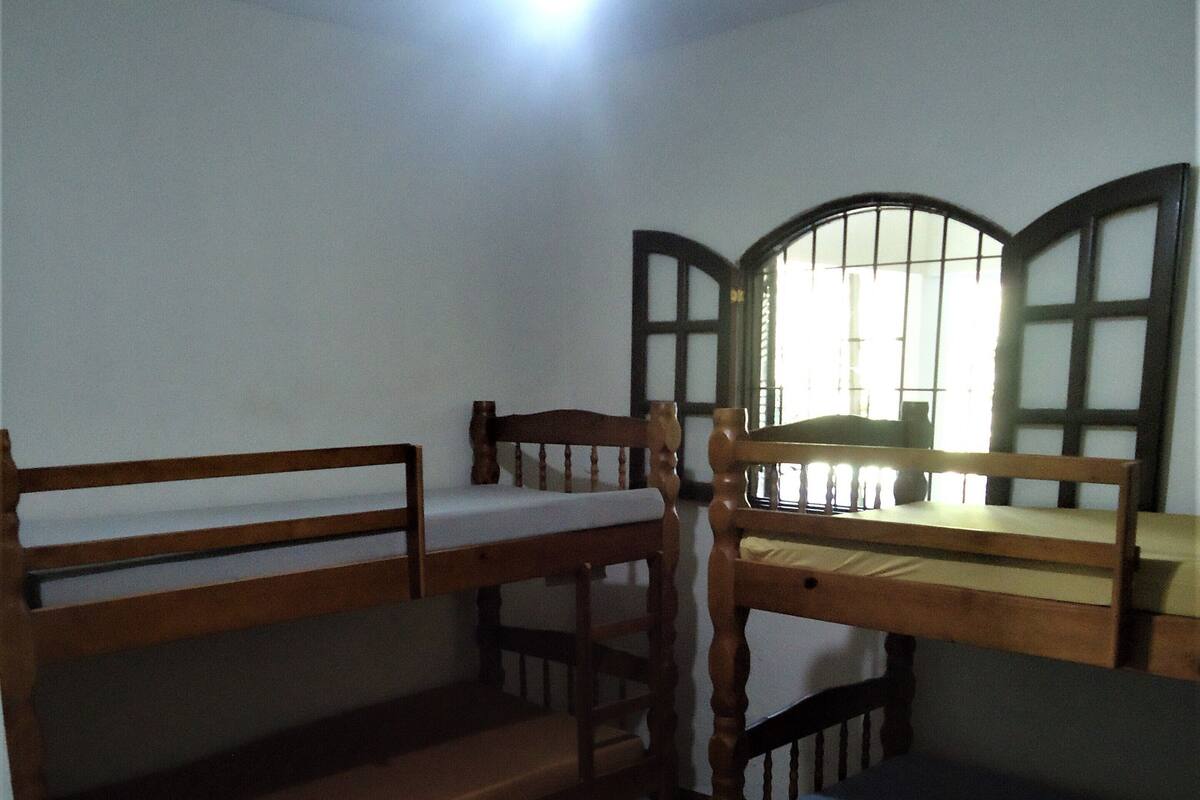 A room with bunk beds, a desk, and a chair.