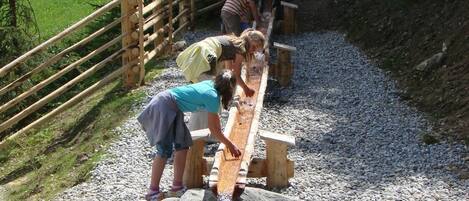 A wooden footbridge over a stream with people crossing.