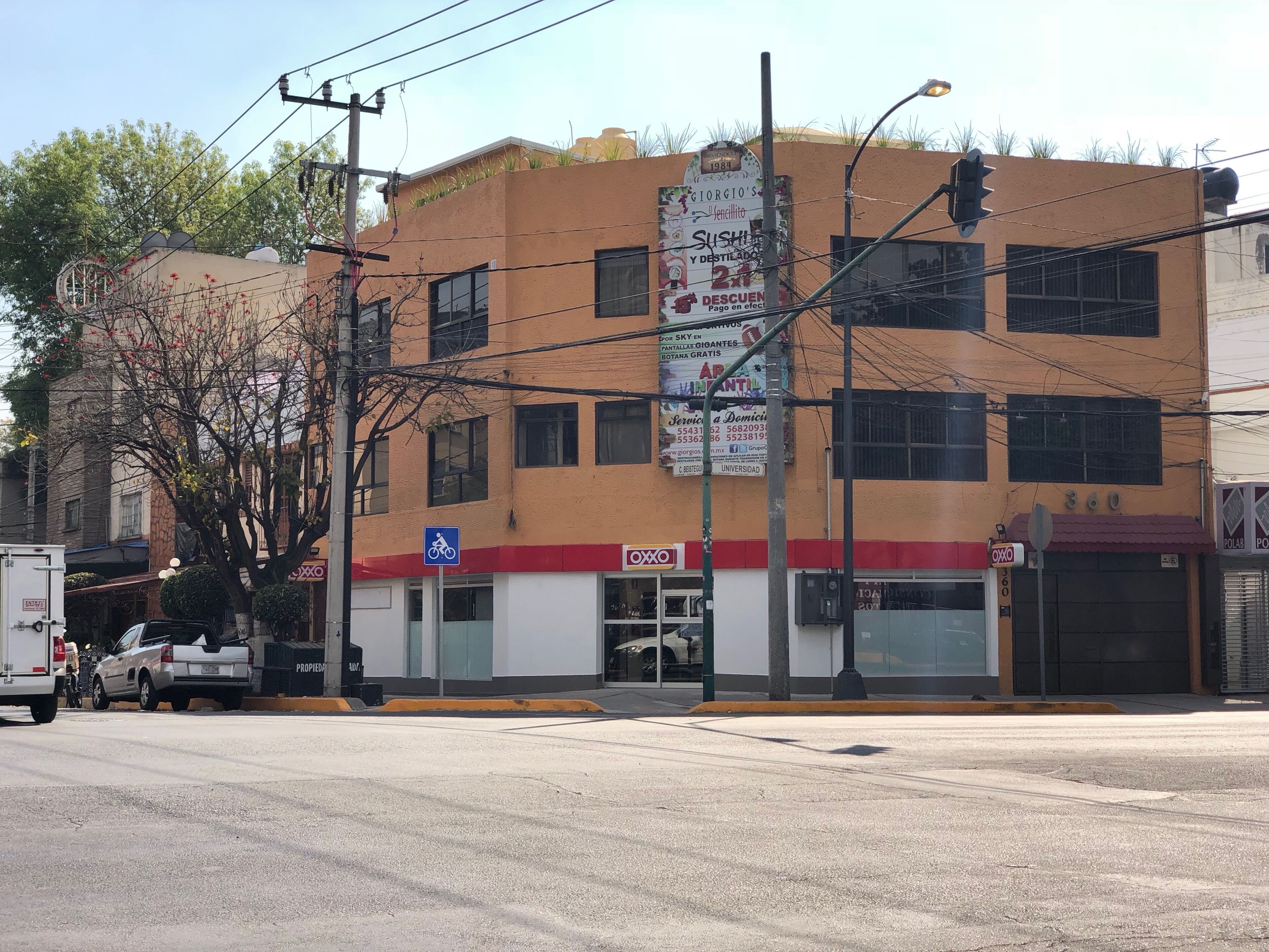 Un edificio con un letrero que indica Giorgio's Sushiya y un cartel para estacionamiento de bicicletas azules.