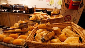 A buffet with various breads and pastries in wicker baskets. - Acqua Inn (Maceió)